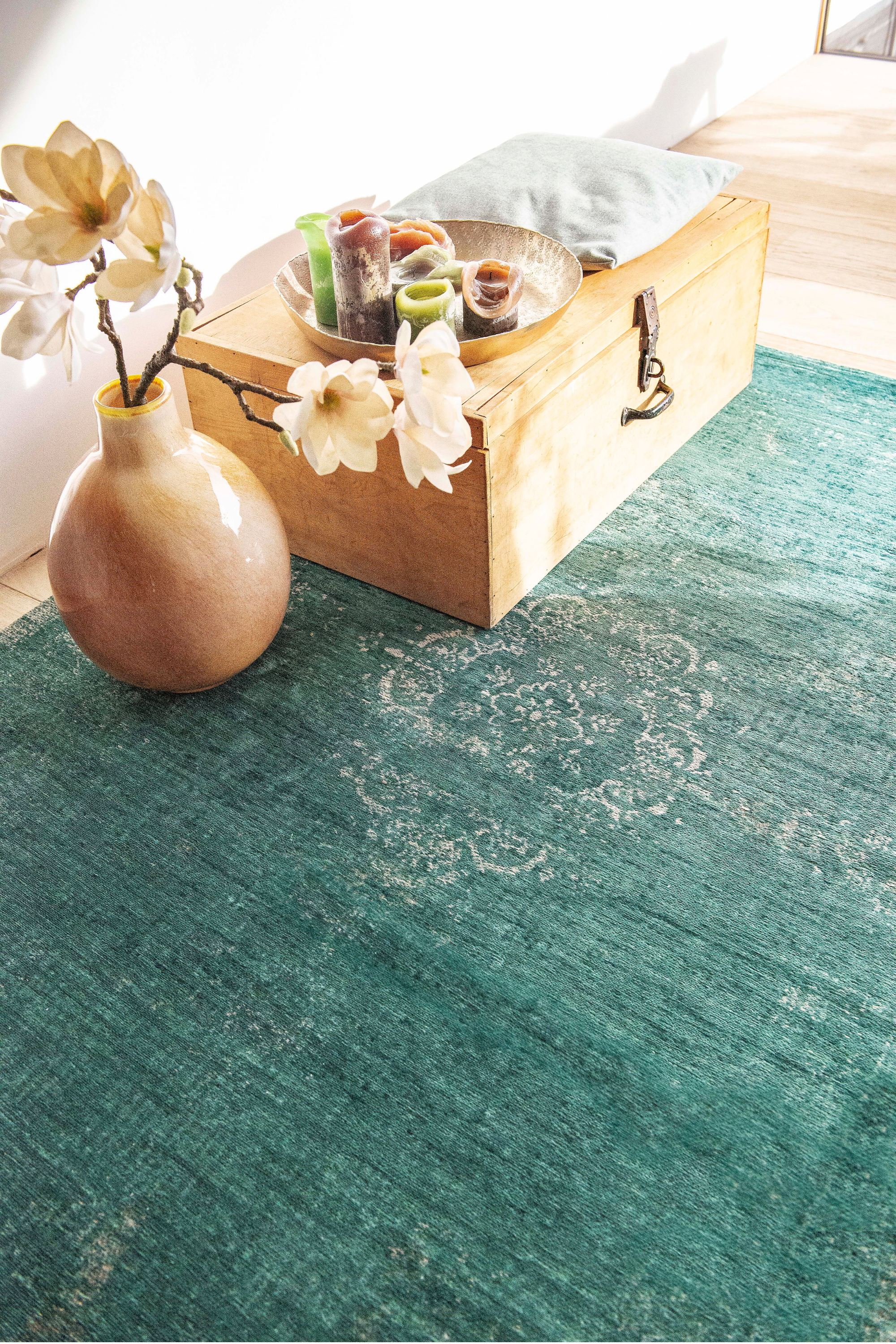 green flatweave rug with faded persian design