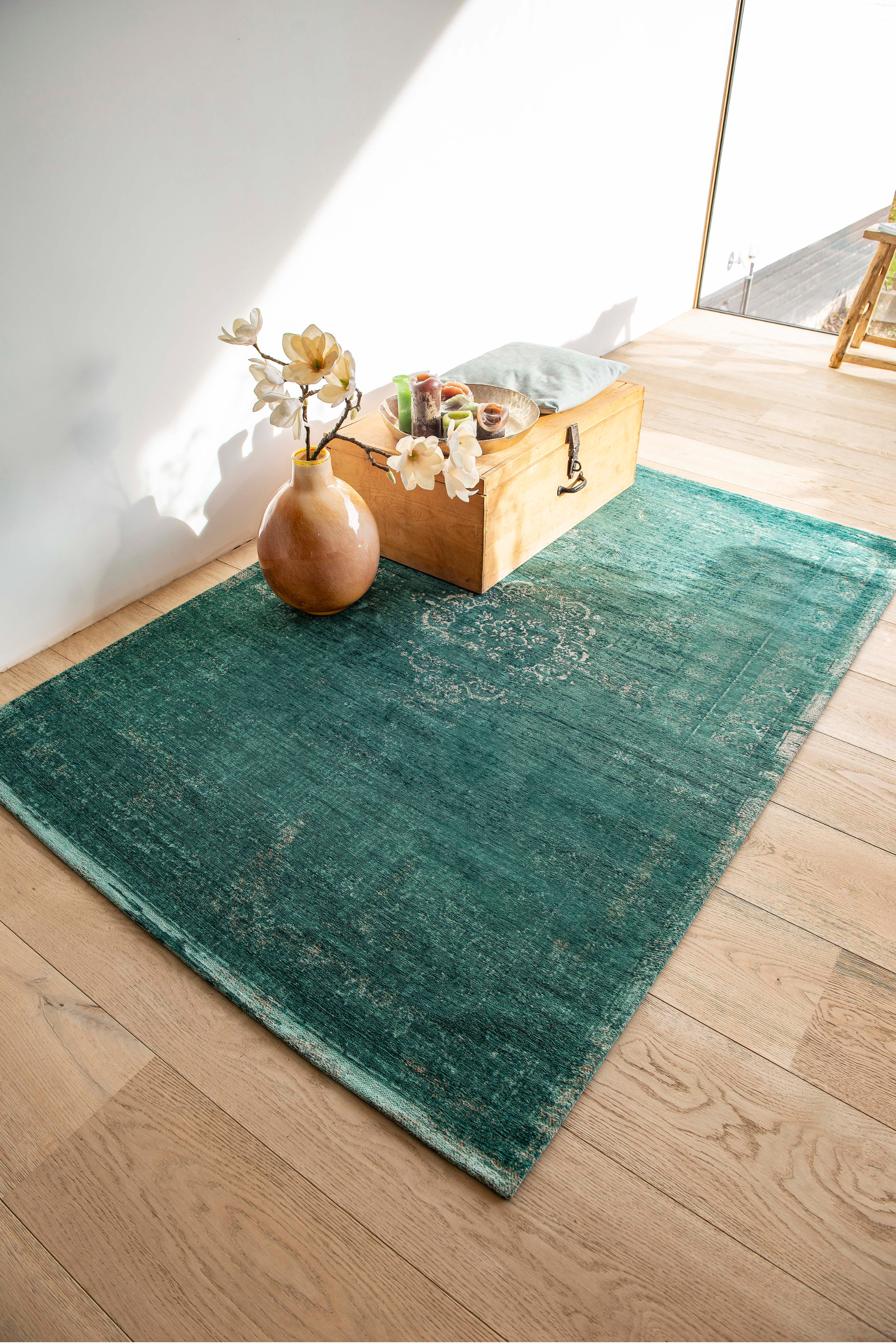 green flatweave rug with faded persian design