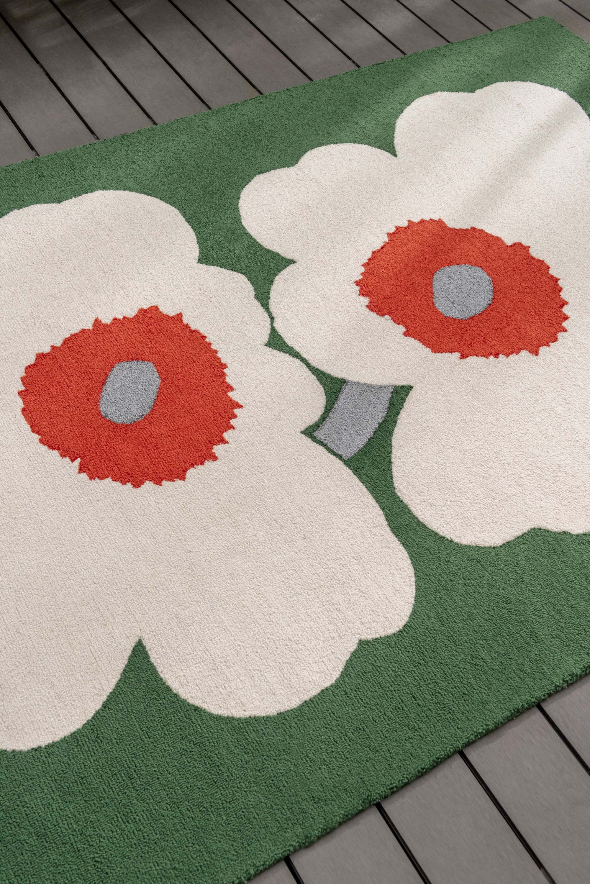 Green rug with white and orange floral motif