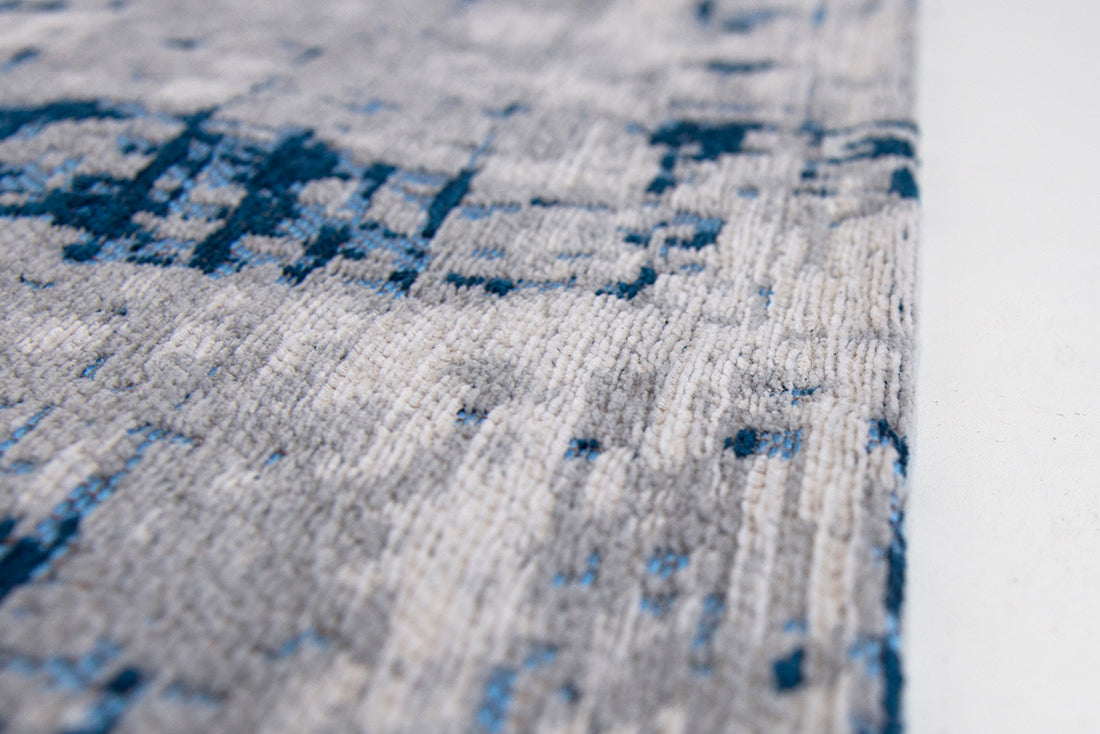 White flatweave rug with grey and blue abstract pattern