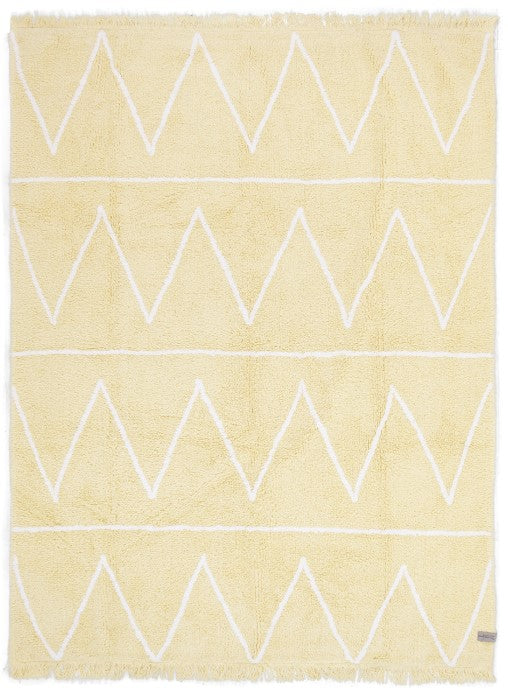 Rectangular yellow rug decorated with white zig-zag design and fringed border