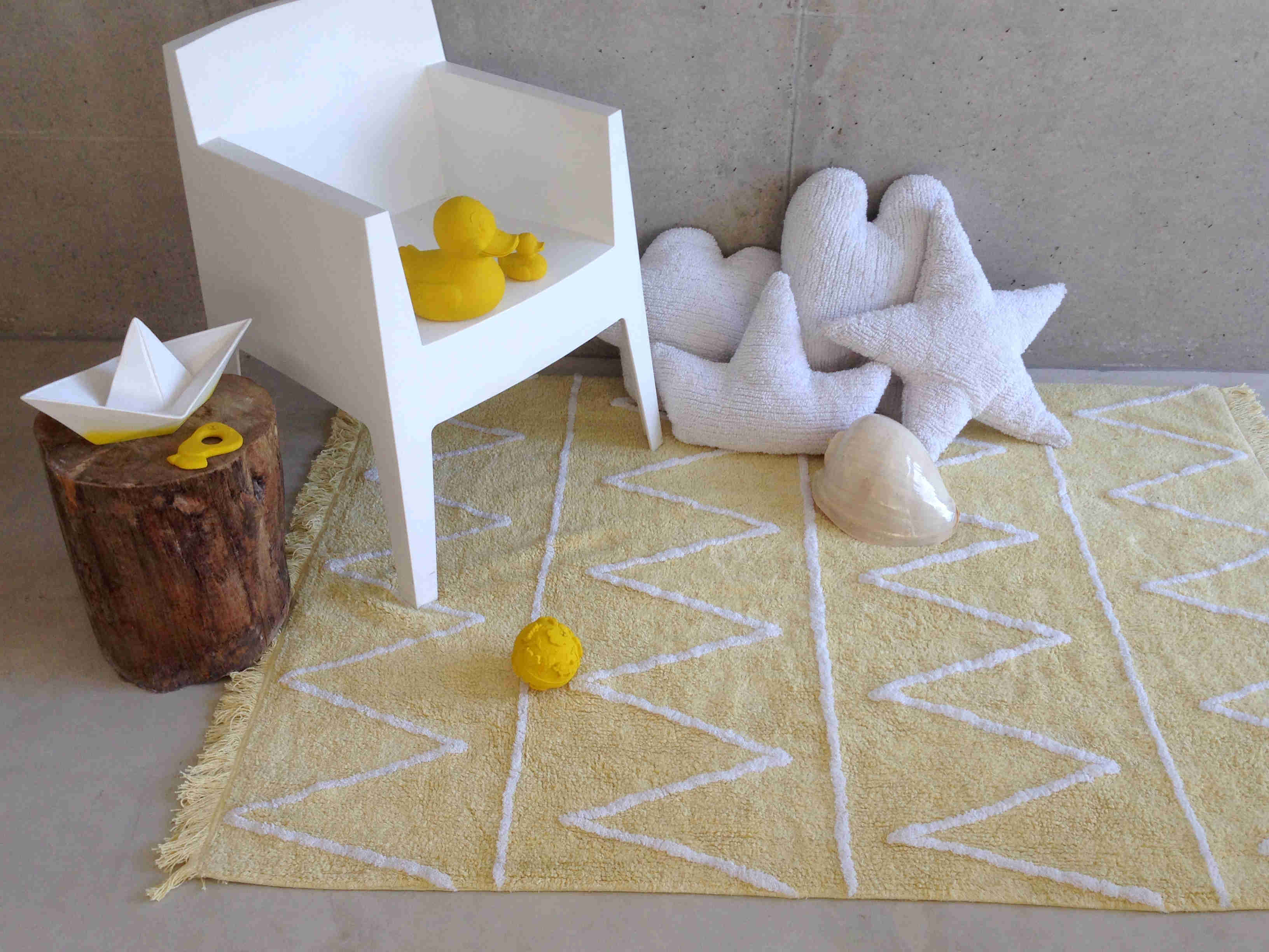 Rectangular yellow rug decorated with white zig-zag design and fringed border