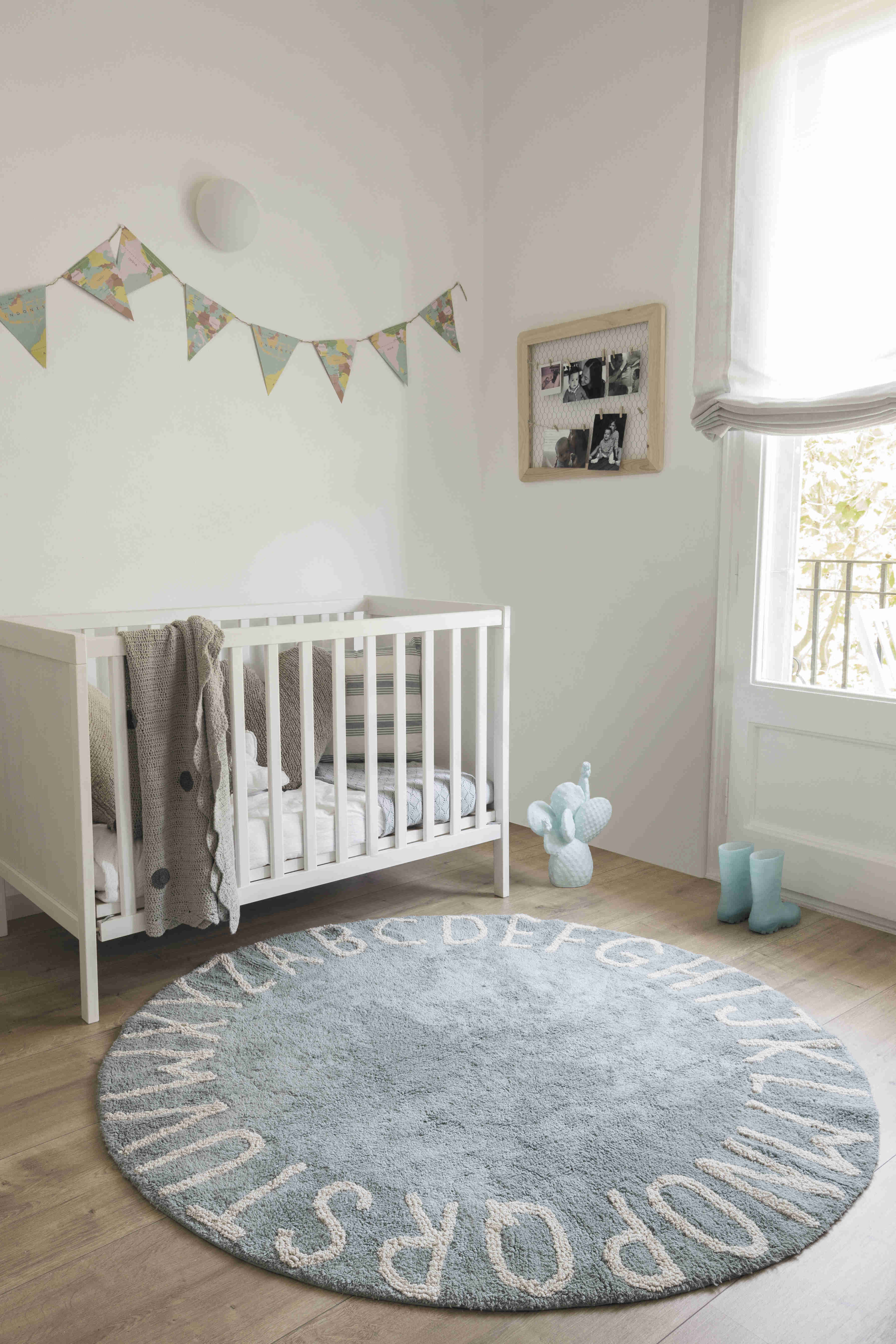 Circular blue cotton rug decorated with a natural beige alphabet border
