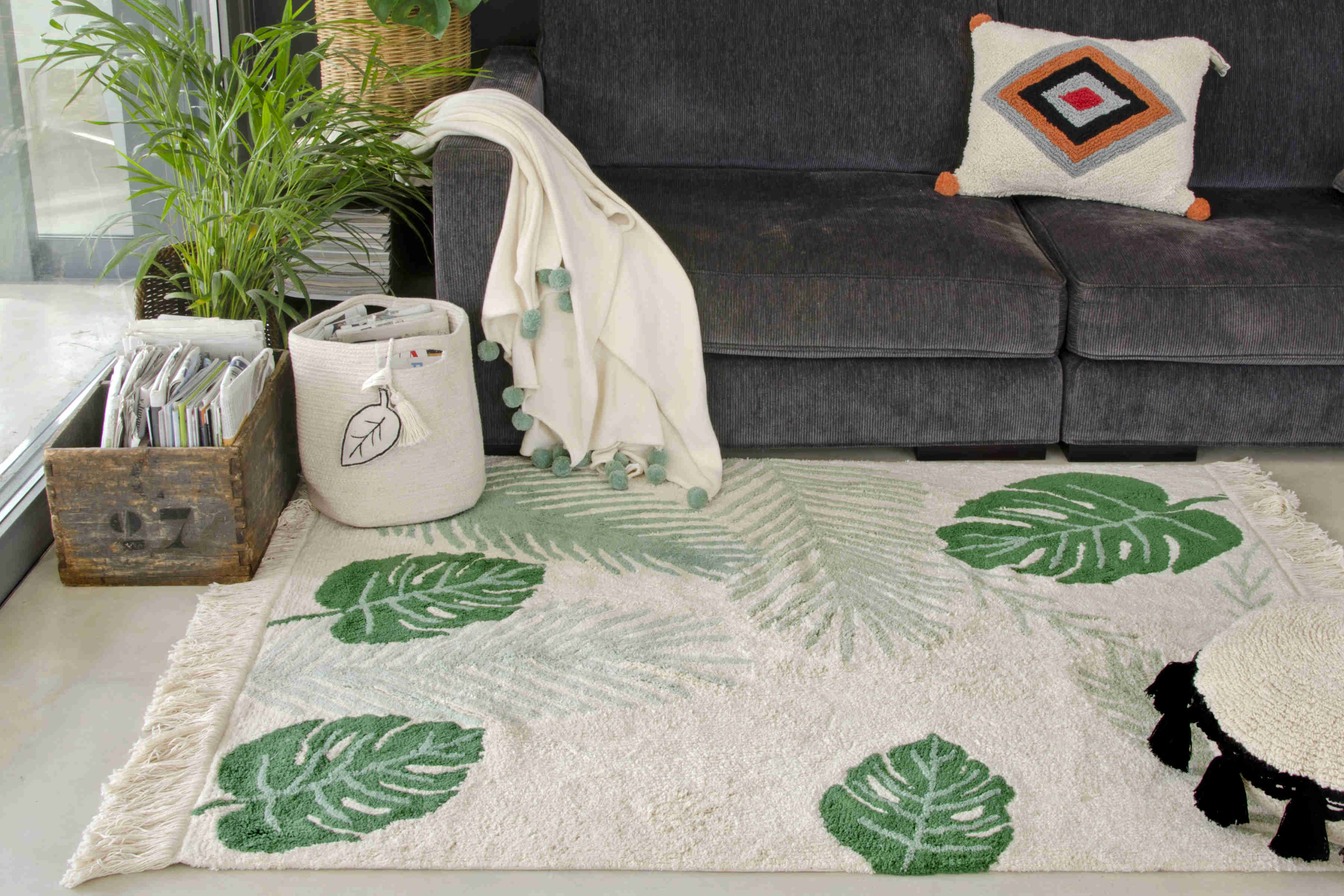 Rectangular beige cotton rug decorated with large green leaves and a fringed border