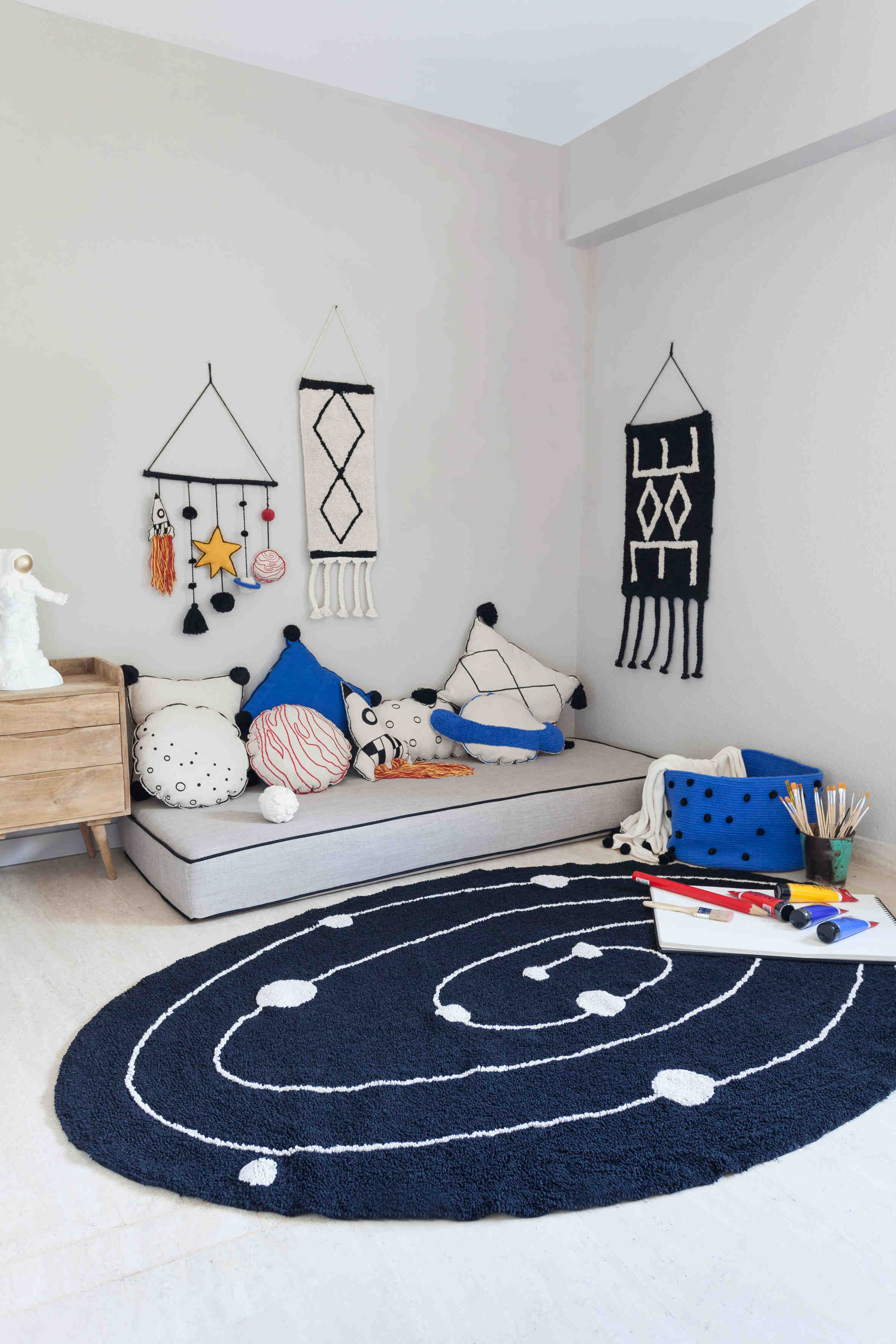 Oval-shaped black cotton rug decorated with an abstract circular design and white circles.