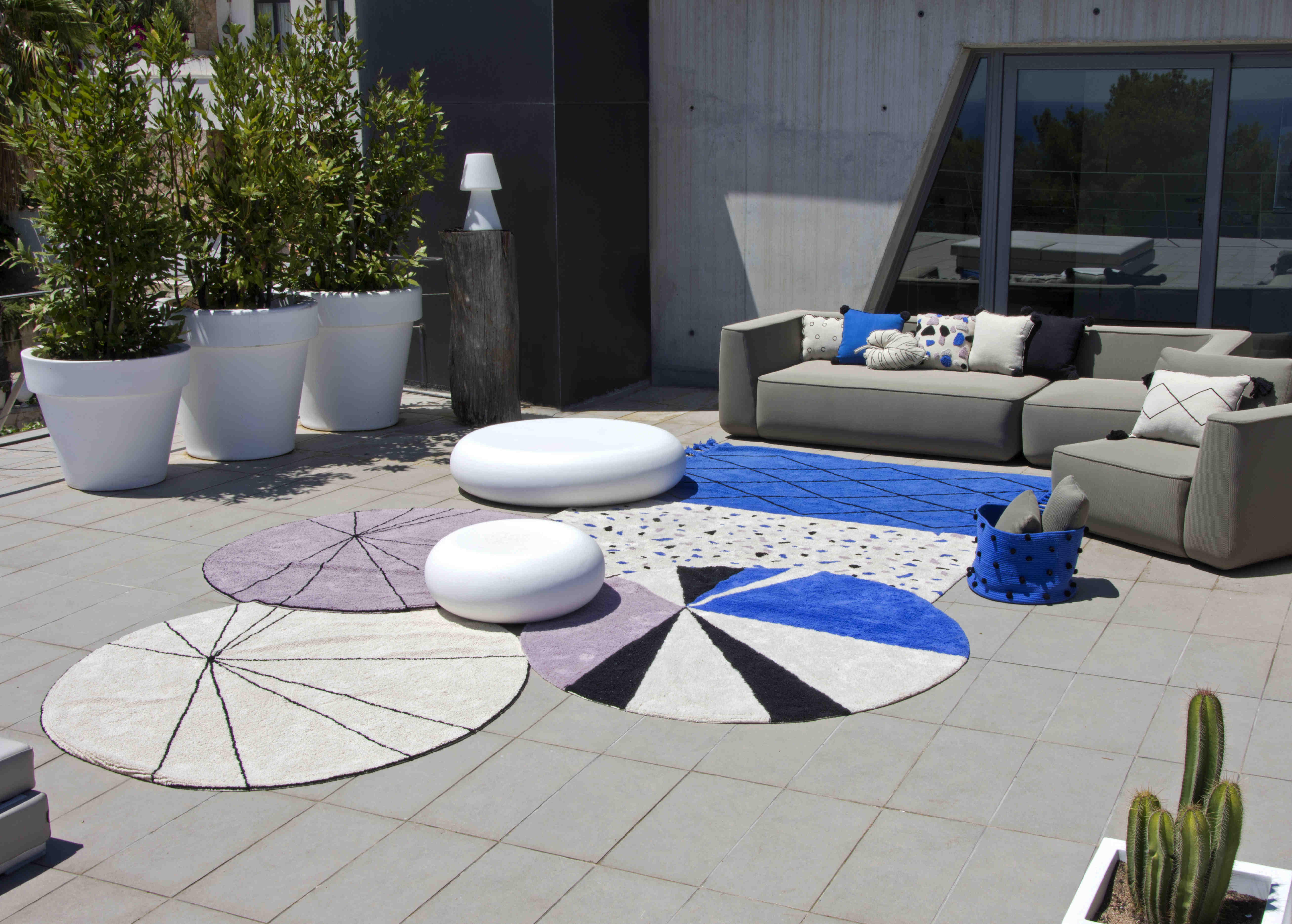A circular shaped beige cotton rug decorated with geometric black lines