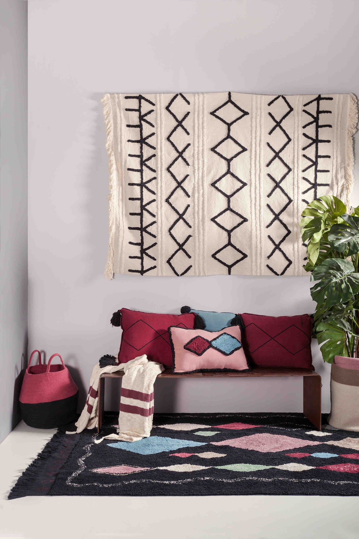 Rectangular beige cotton rug decorated with a black moroccan tribal design and a fringed border