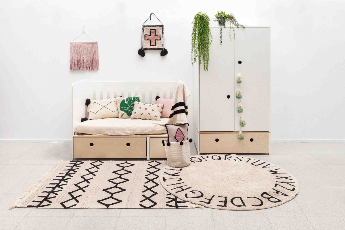Rectangular beige cotton rug decorated with a black moroccan tribal design and a fringed border