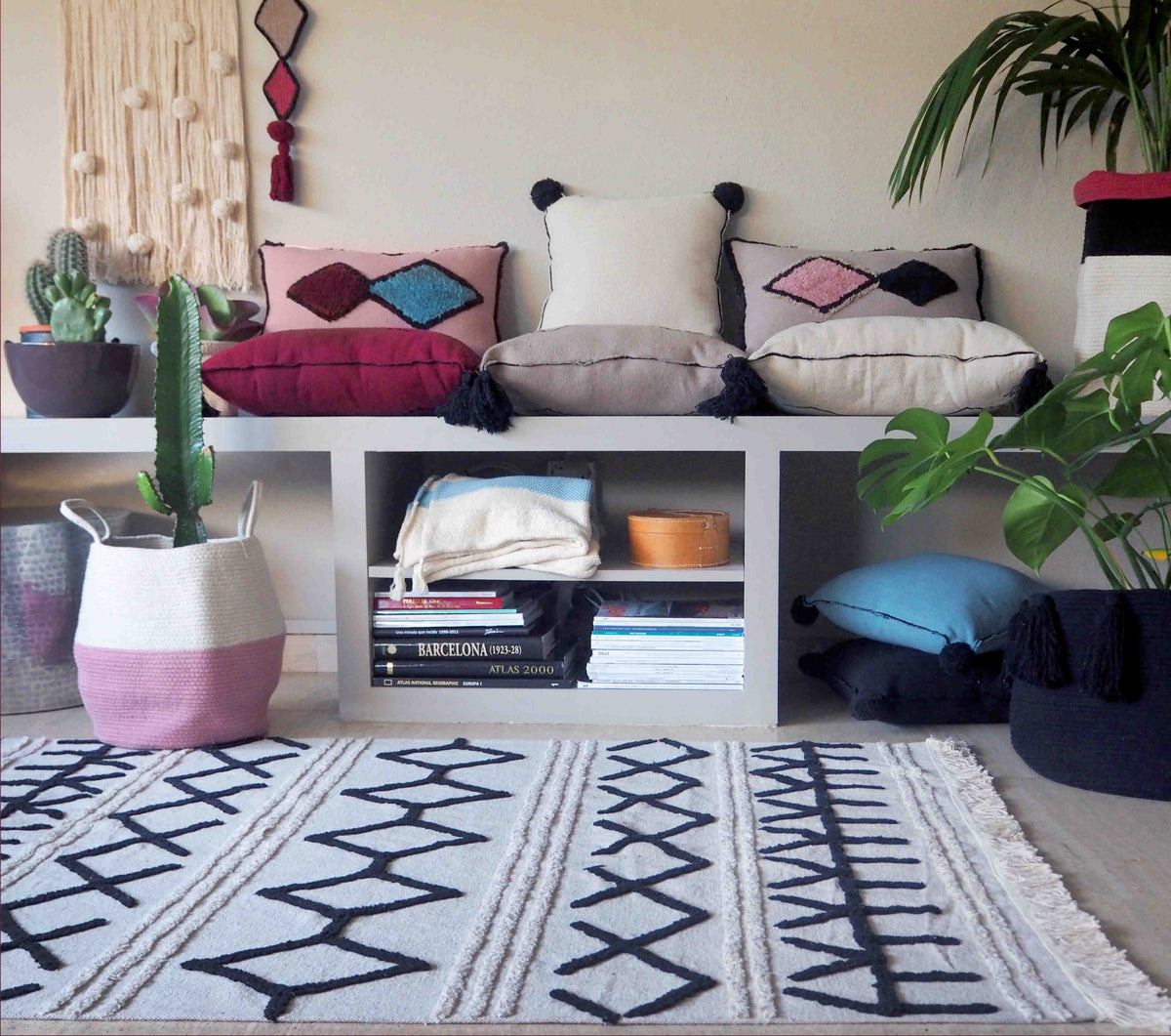 Rectangular beige cotton rug decorated with a black moroccan tribal design and a fringed border