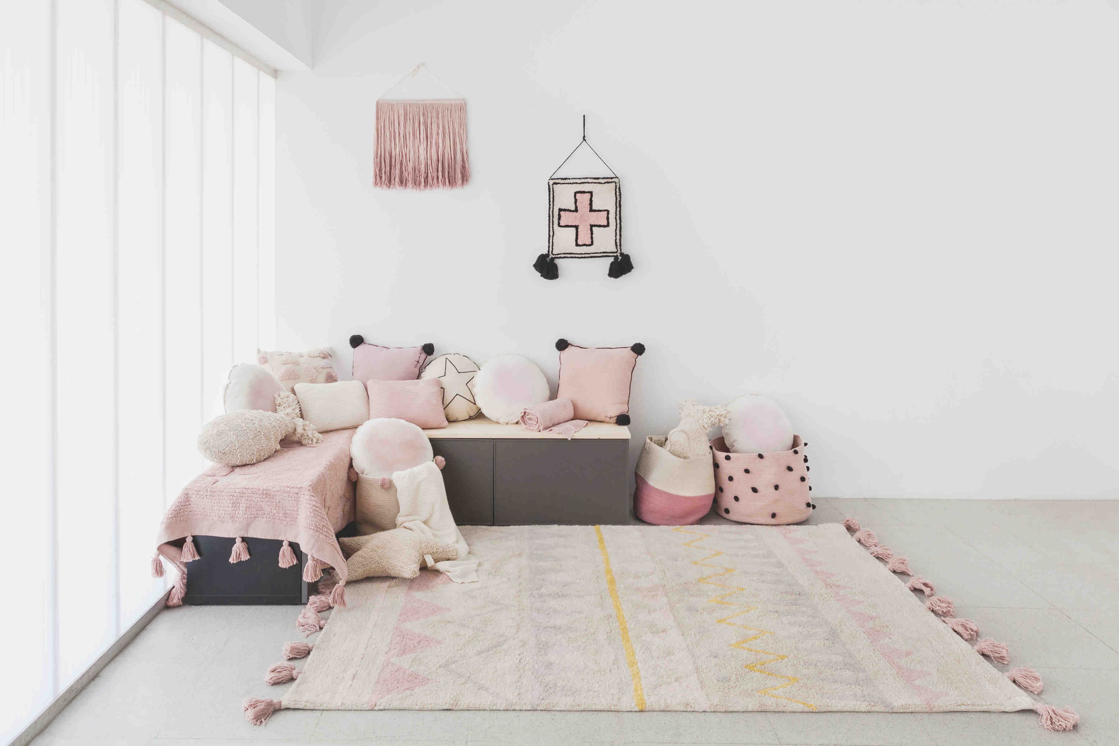 Rectangular pink cotton rug decorated with exposed stars and a tassel border.