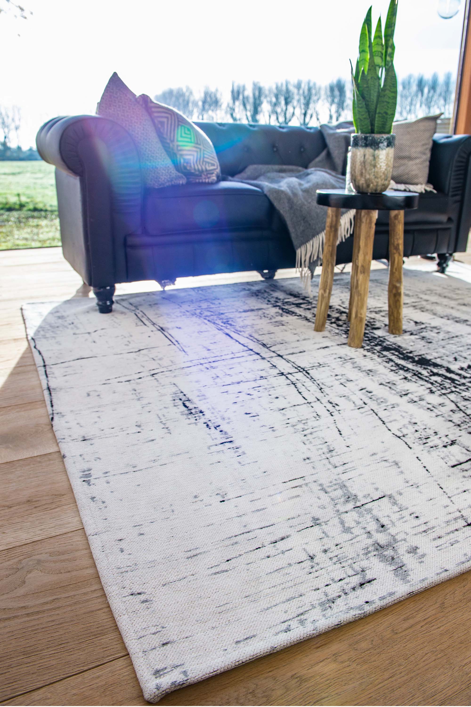 White flatweave rug with grey and black abstract pattern