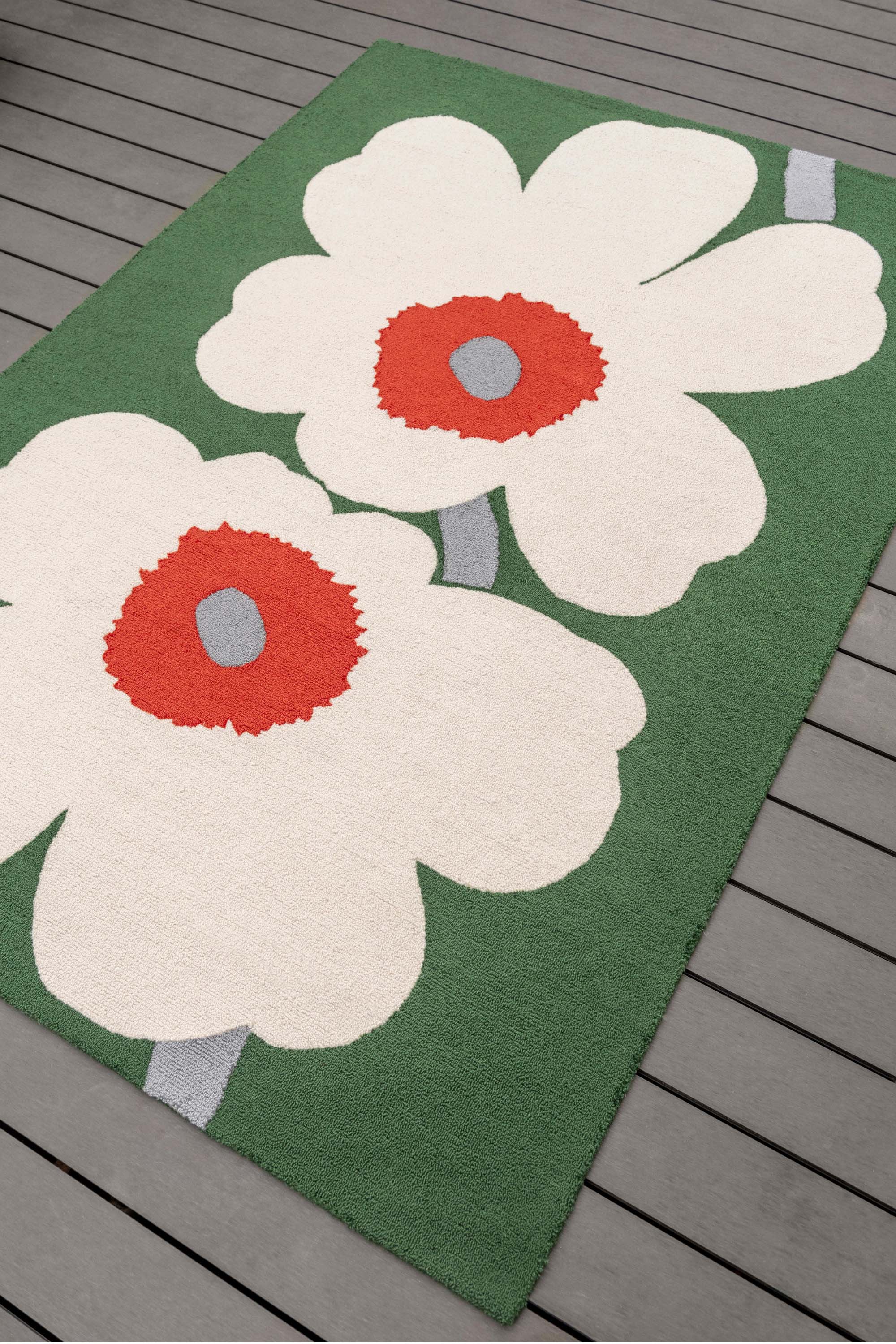 Green rug with white and orange floral motif