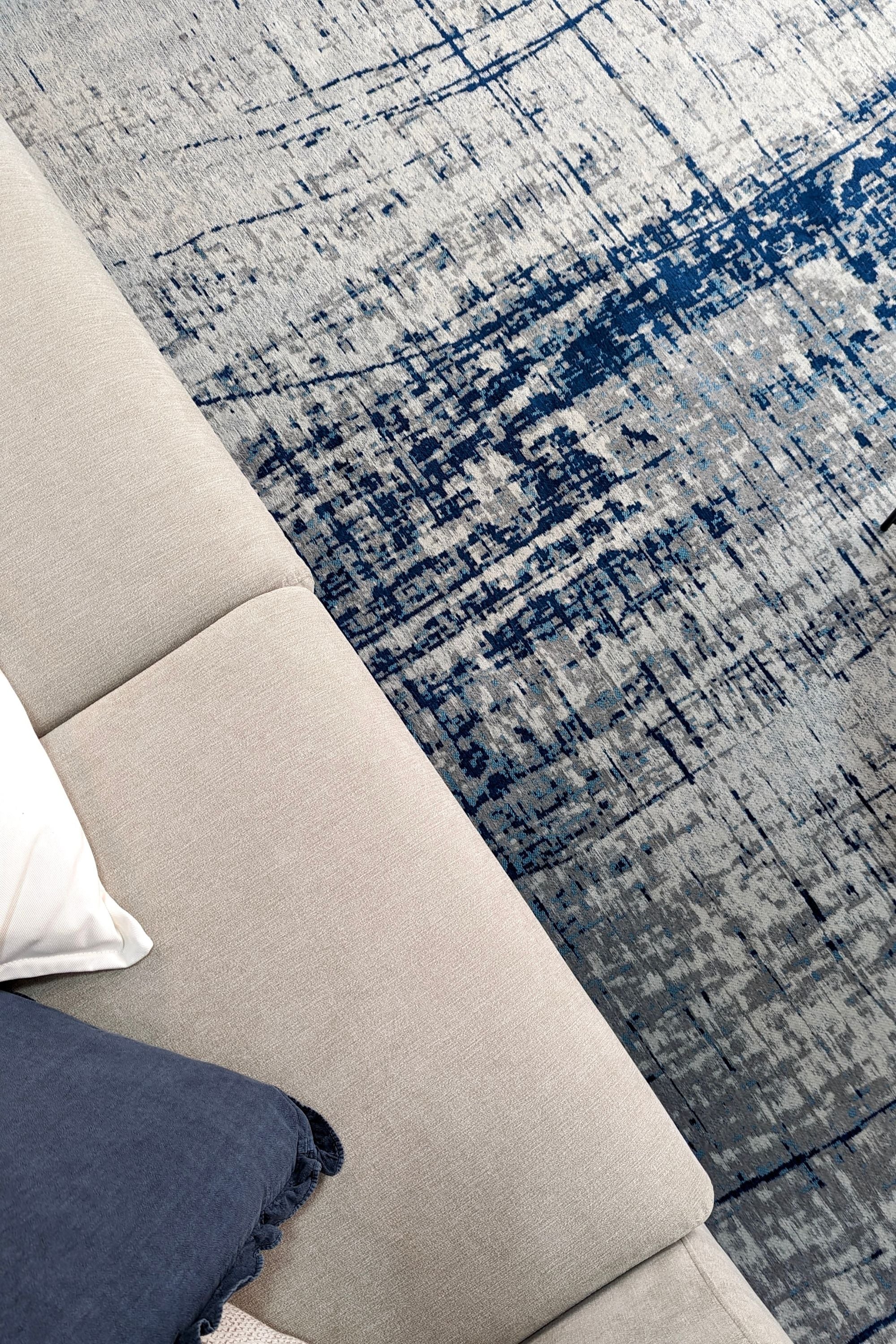 White flatweave rug with grey and blue abstract pattern