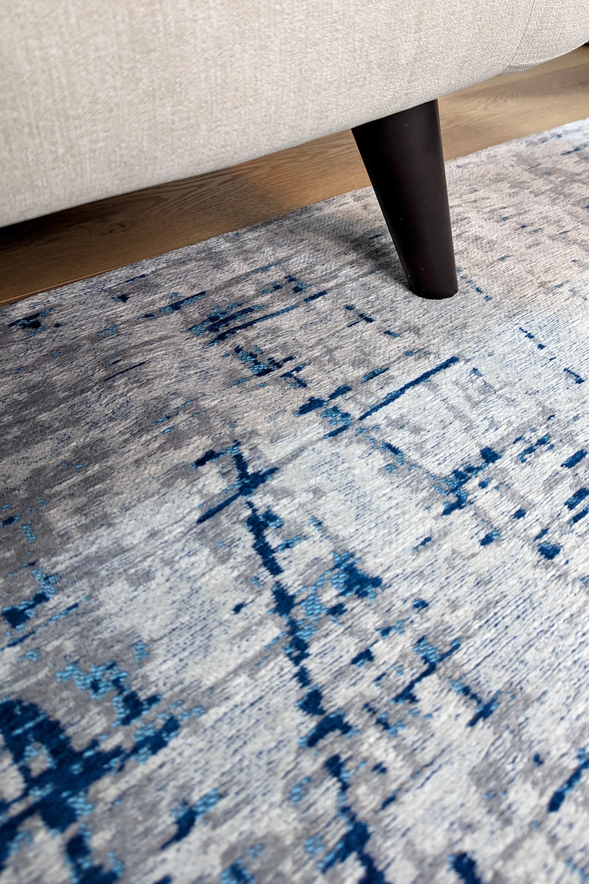 White flatweave rug with grey and blue abstract pattern