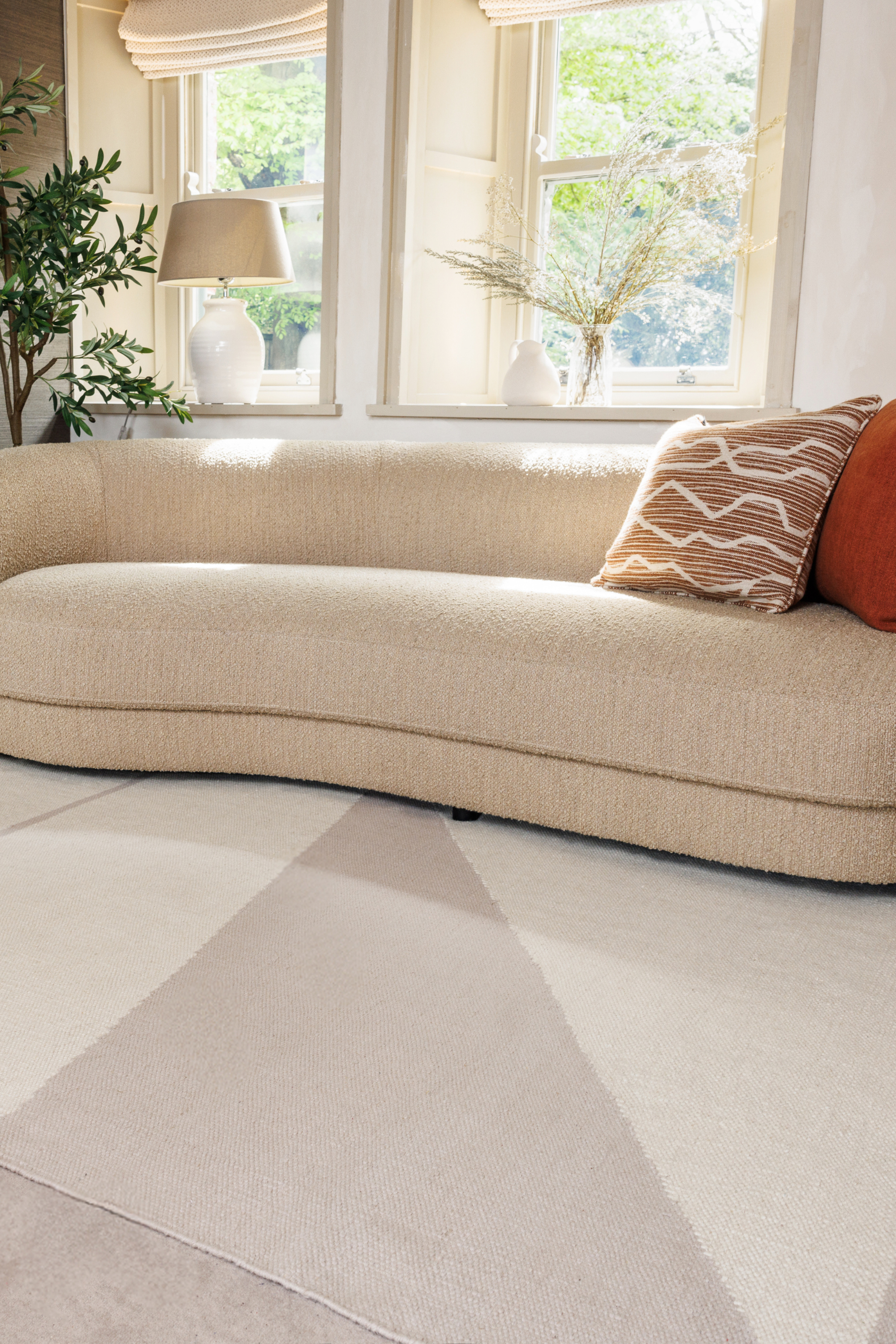Neutral greige wool and cotton rug featuring an ivory angular design placed in a living room 