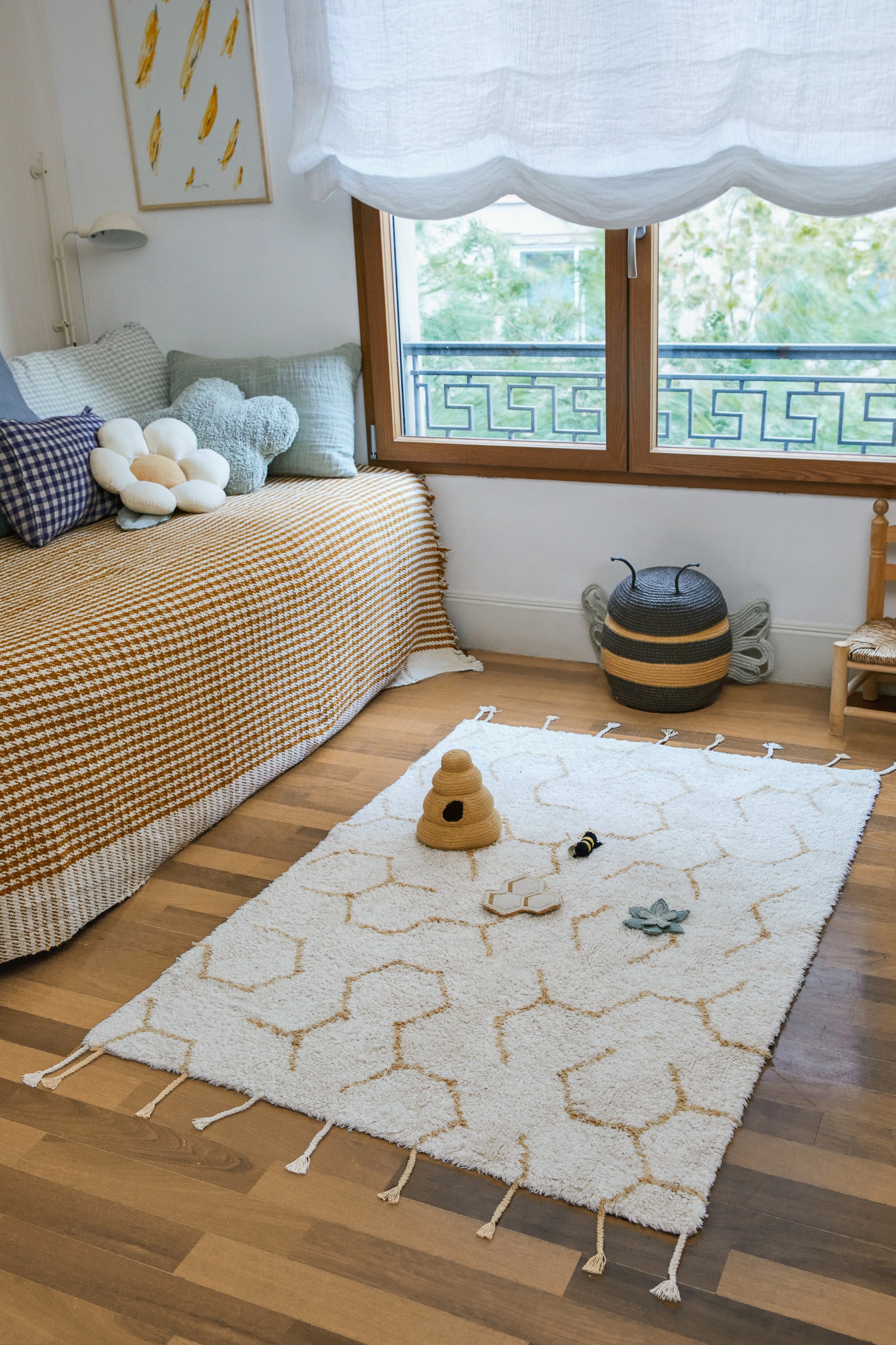 Cream rug with minimal yellow honeycomb pattern and honeybee toys