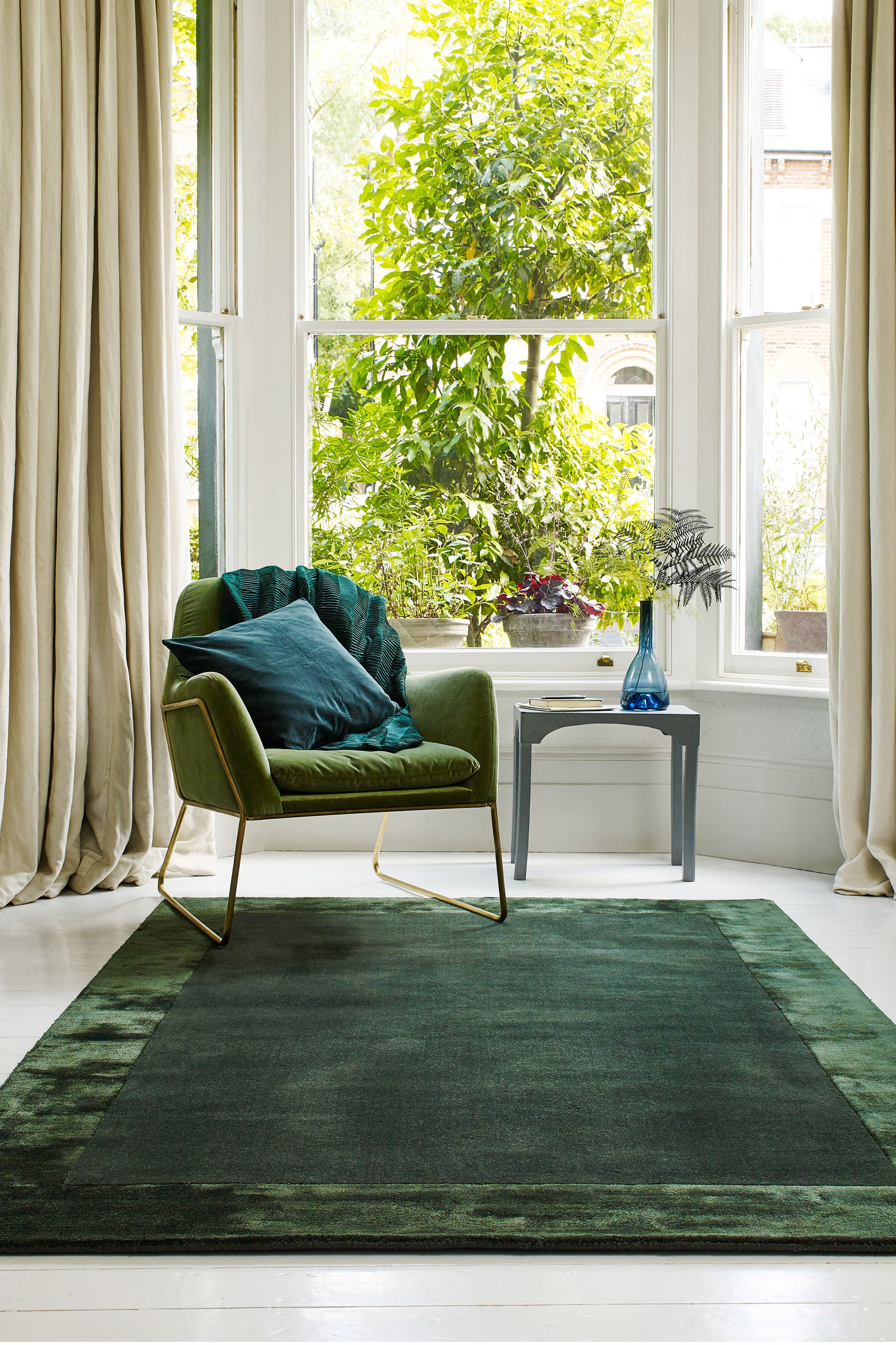 green wool and viscose rug with a border design
