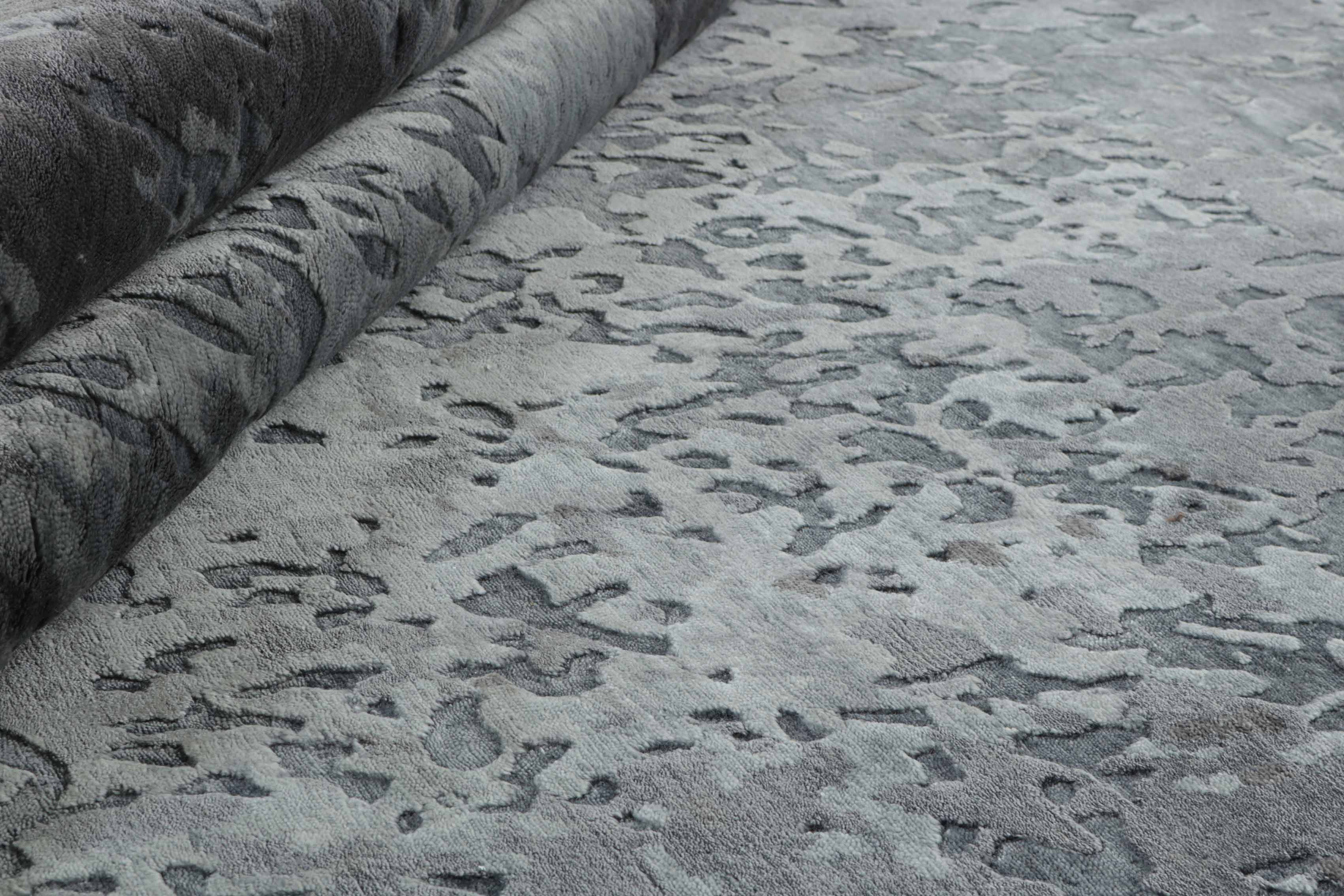 Area rug with abstract design in grey and beige