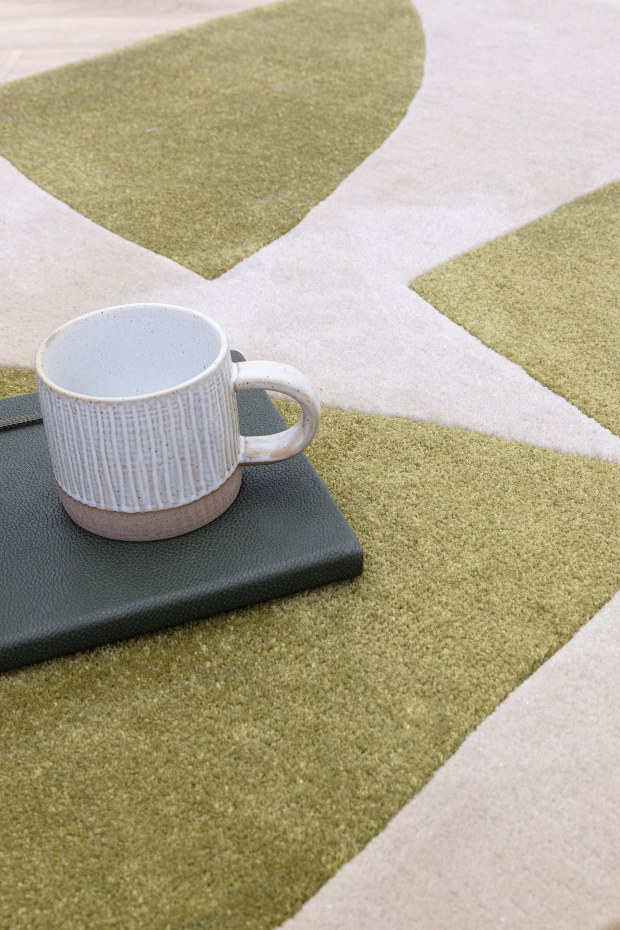 Sage green and cream rug with abstract pattern