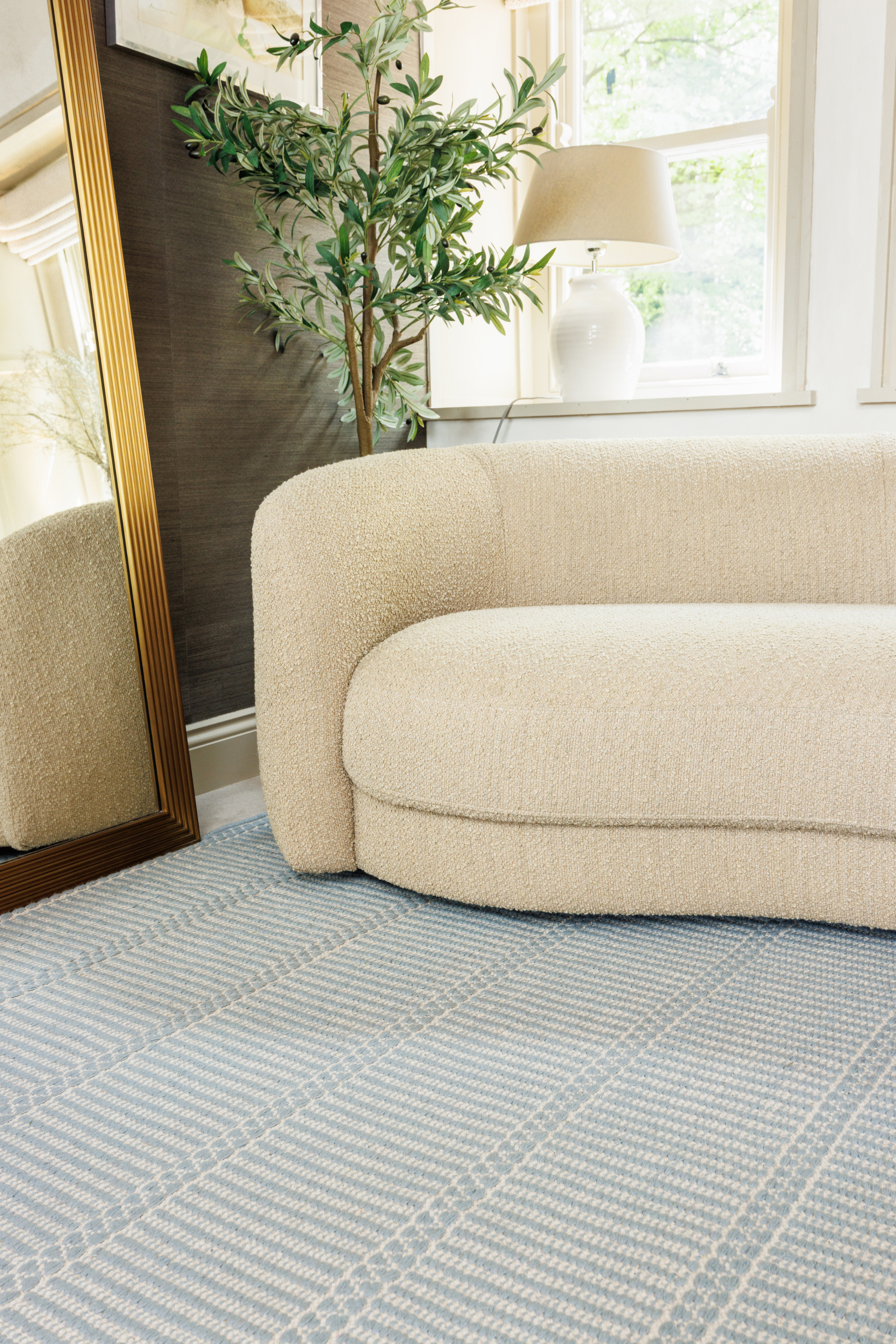 Blue wool and cotton rug featuring a design inspired by ancient irish script placed under a couch in a living room 