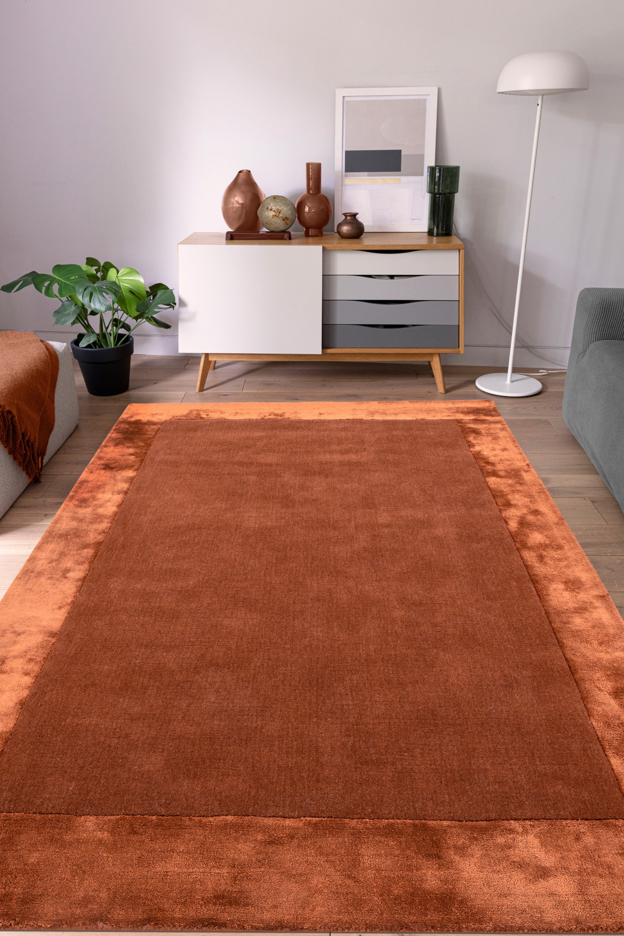 Orange wool and viscose rug with a border design