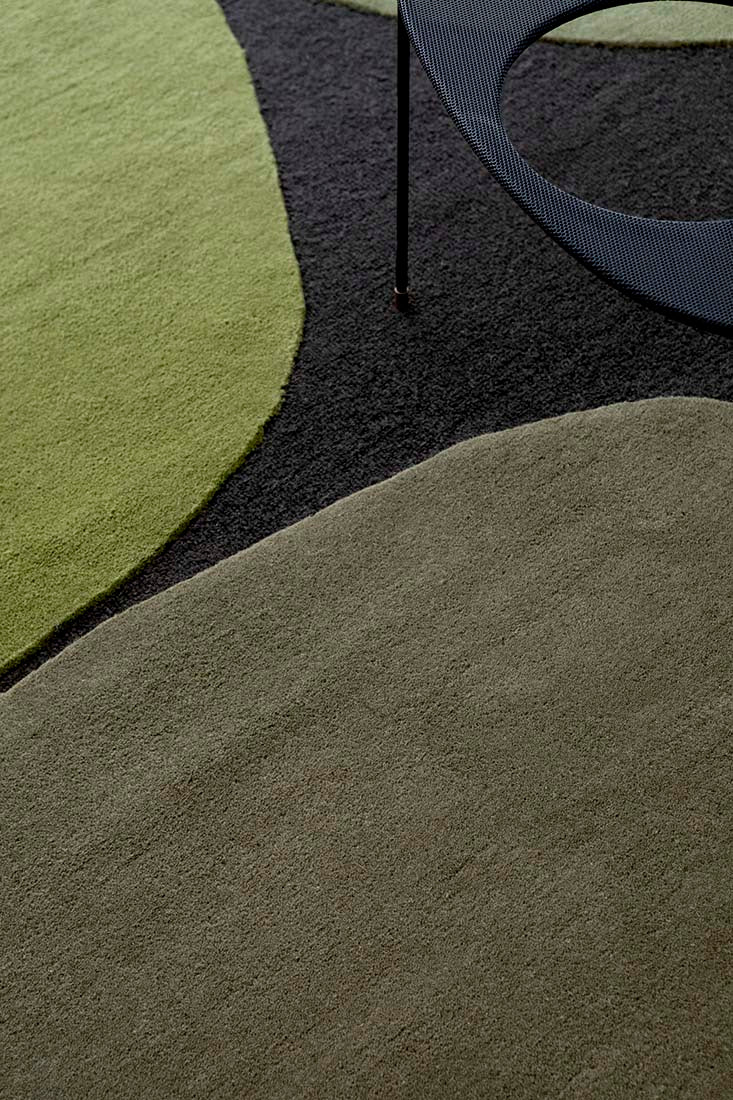 black wool rug with green shapes 
