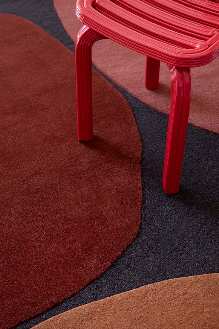black wool rug with red shapes 
