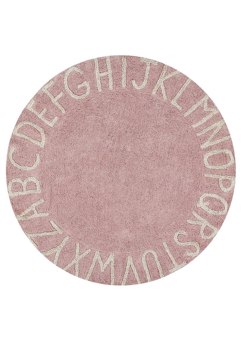 Circular pink cotton rug decorated with a natural beige alphabet border
