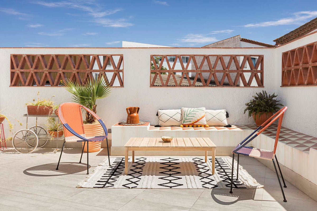 Rectangular beige cotton rug decorated with a black moroccan tribal design and a fringed border