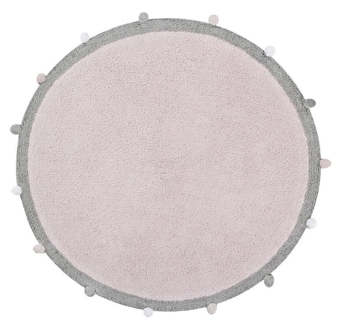 Circular pastel pink cotton rug decorated with a grey and white pom pom border