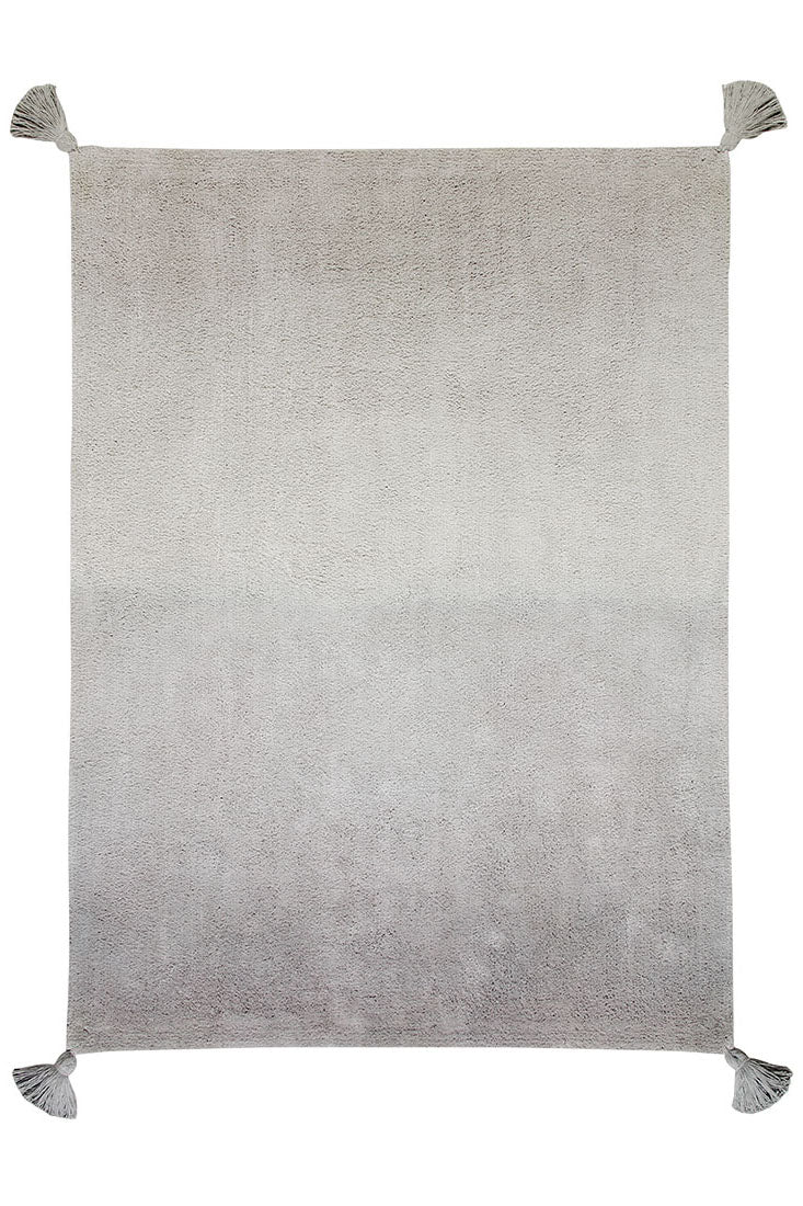 An ombre grey and green rectangular cotton rug. Large tassel on each corner.