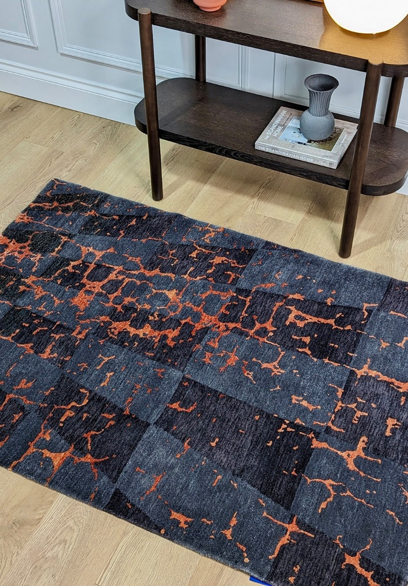 abstract modern style rug in grey, black, red and orange 
