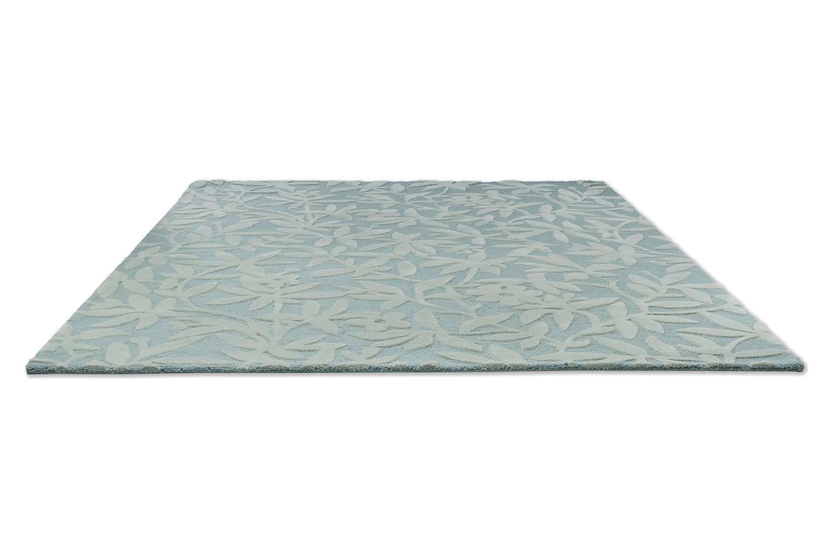Green and blue wool rug with hand carved floral motifs
