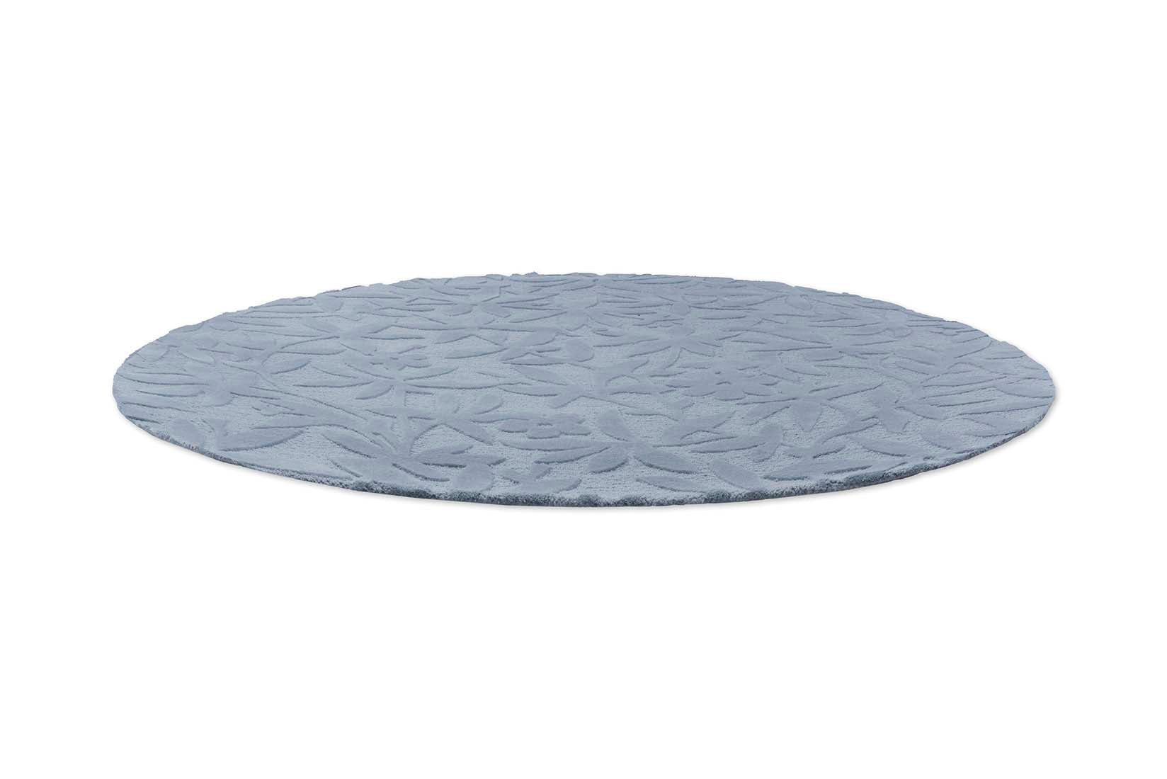 Blue wool circular rug with hand carved floral motifs
