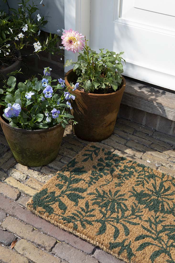 Coir doormat with green floral pattern
