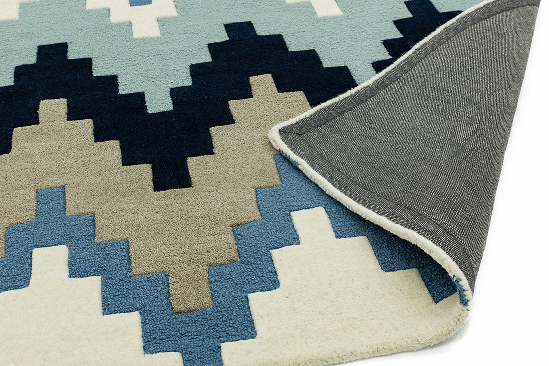 grey and blue rug with a geometric zig zag design