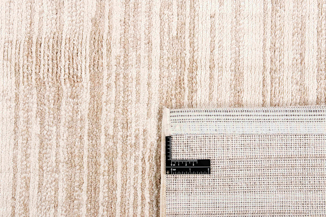 Cream rug with a subtle striped beige pattern 
