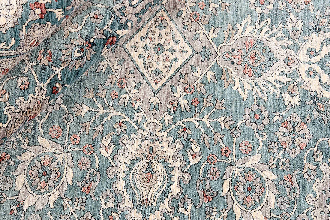 Traditional style rug with beige backing and teal patterned border design
