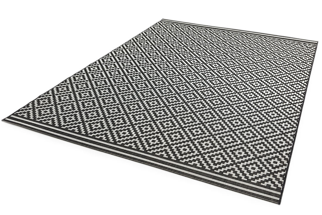 Woven grey and white rug with a modern geometric diamond pattern