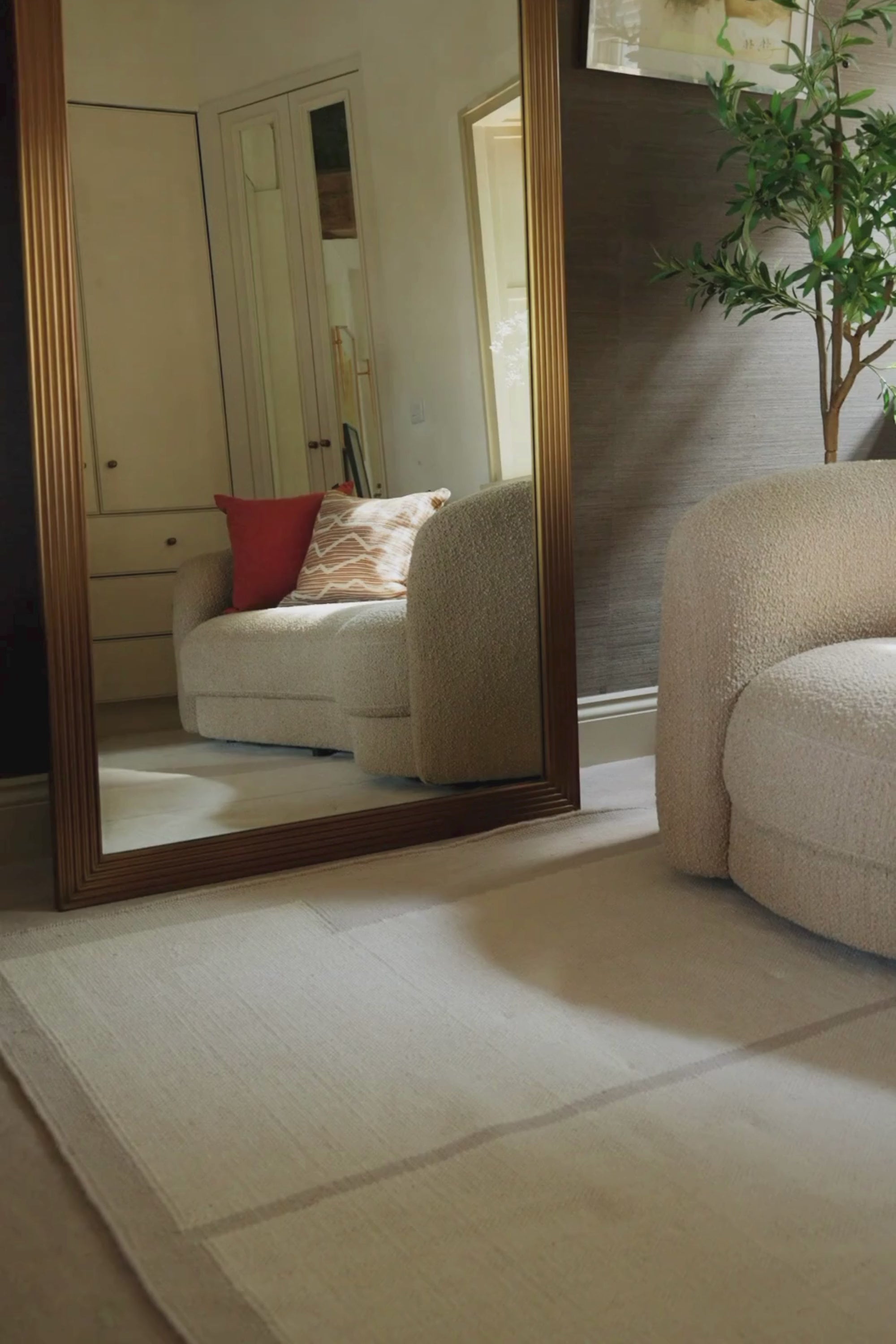 a video of a neutral greige wool and cotton rug featuring an ivory angular design placed in a living room