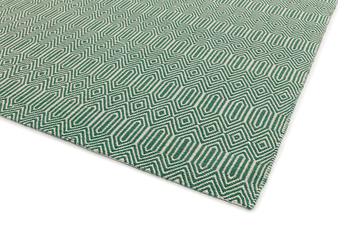 green and white rug with a geometric aztec design