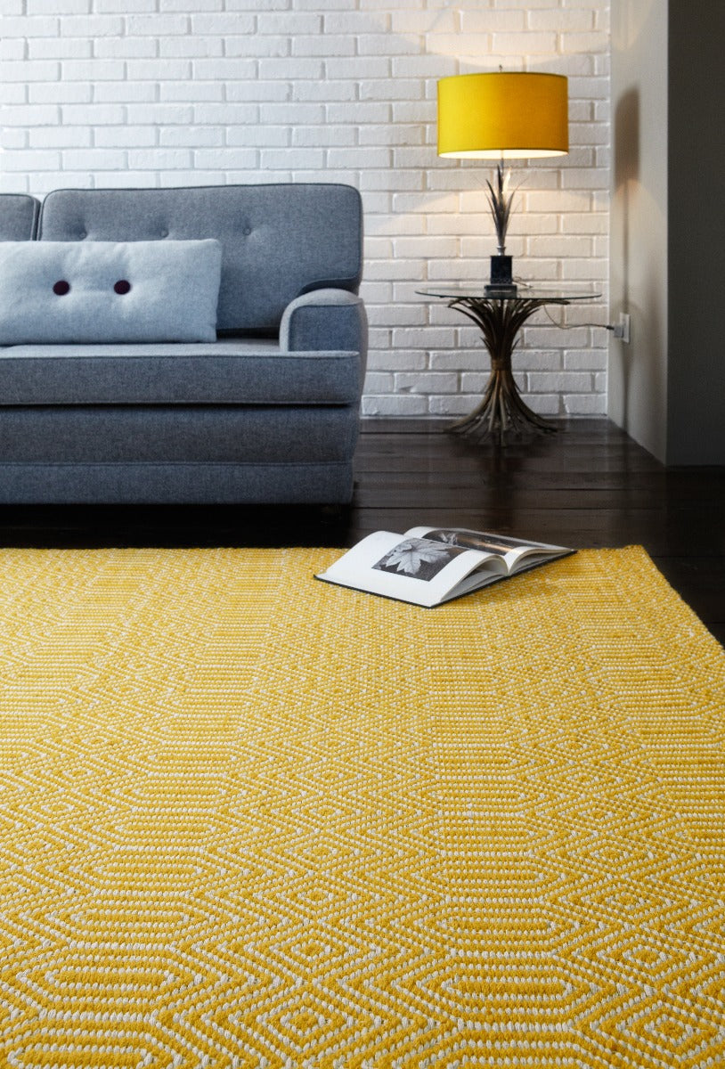mustard yellow and white rug with a geometric aztec pattern