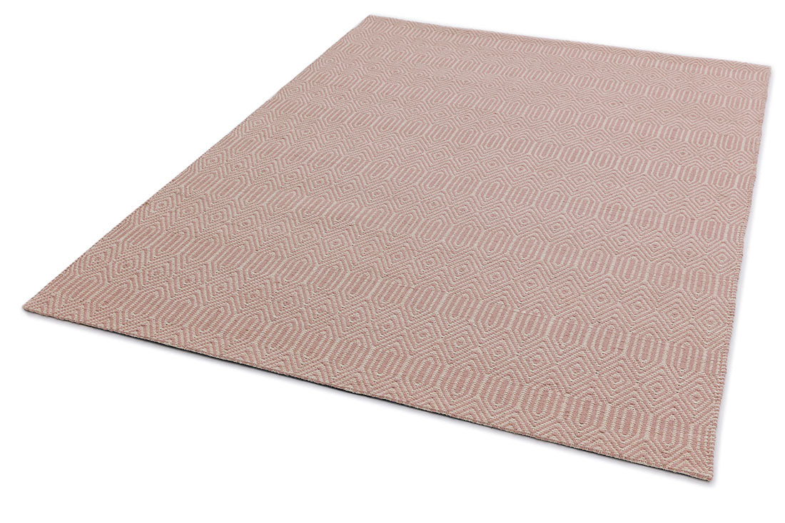 pink and white rug with a geometric aztec pattern
