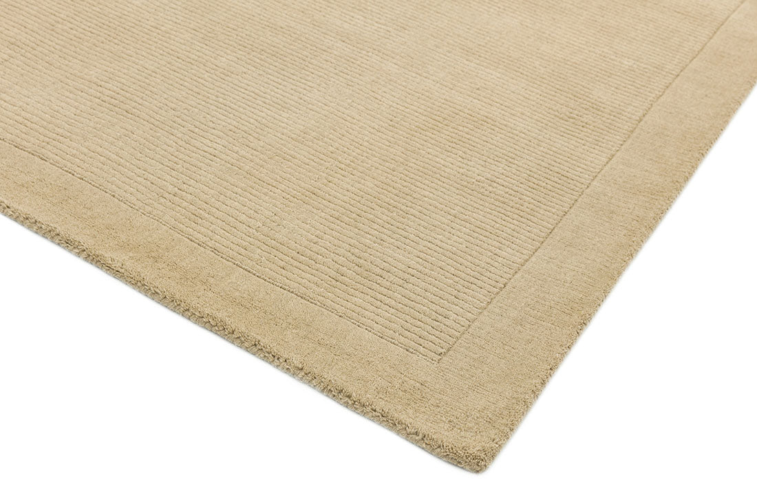 A plain beige rectangle-shaped wool rug with thin border.