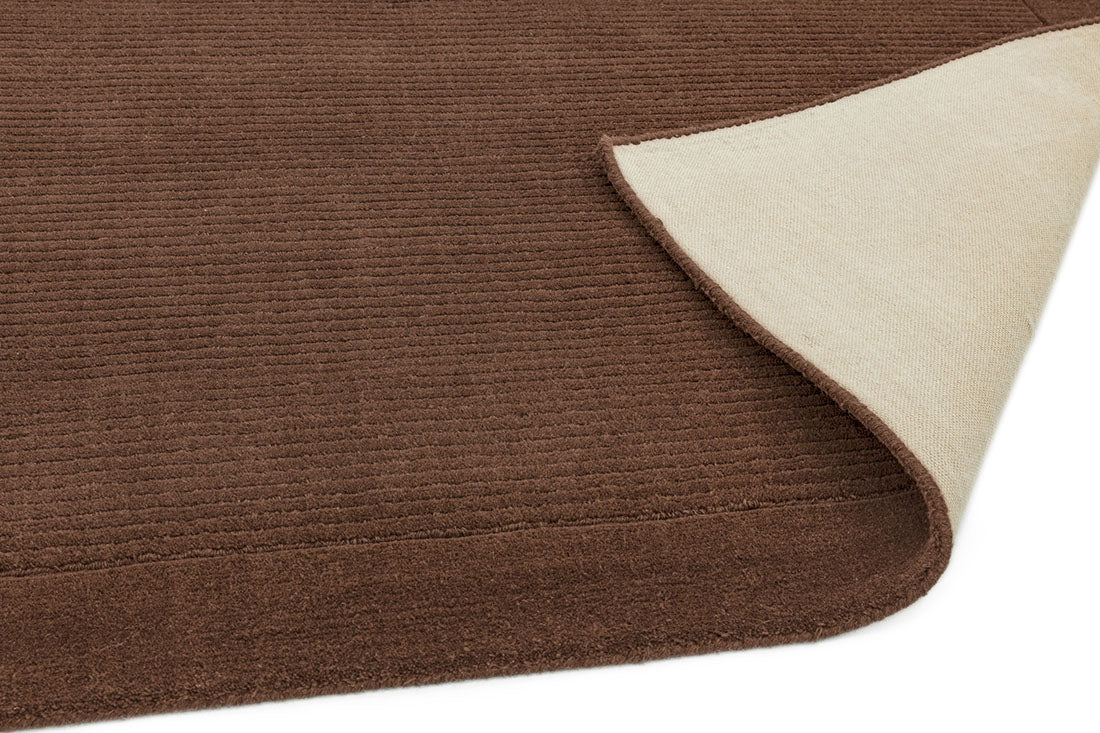 A plain brown rectangle-shaped wool rug with thin border.