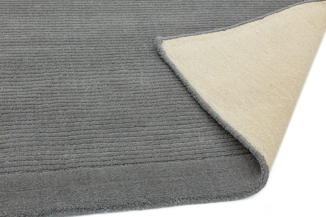 A plain grey rectangle-shaped wool rug with thin border.