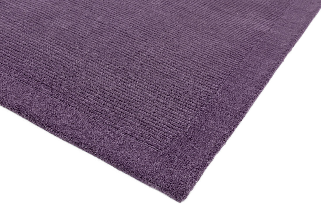 A plain purple rectangle-shaped wool rug with thin border.
